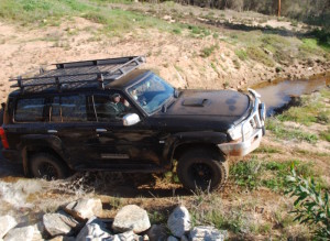 Tim takes his Patrol through the small riverbed.