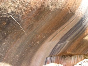 Strips of silicone are placed on the rock to protect the artwork from water.