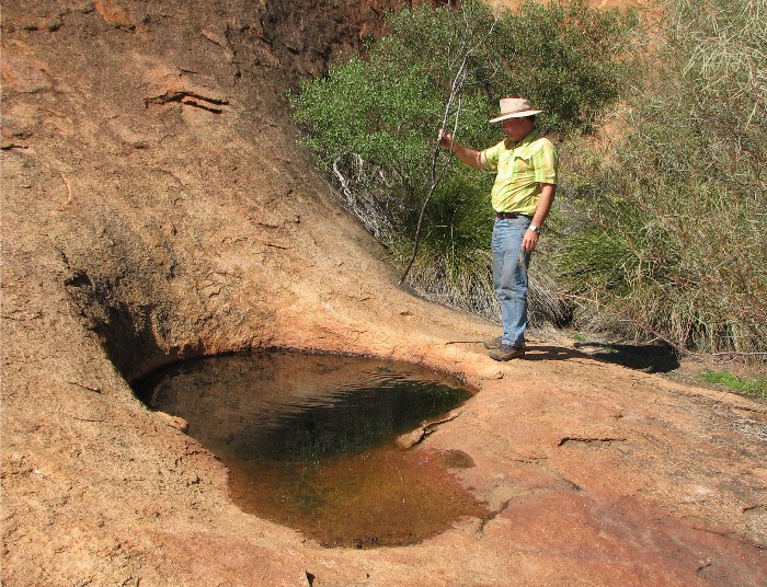 Measuring the depth of the water in the gnamma at Walga Rock.