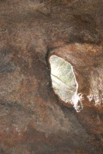 A hole has been weathered away in a wall of Kings Cave.