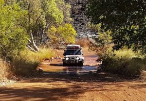 Nick and Carrie in their Jeep Wrangler through the Lennard River.