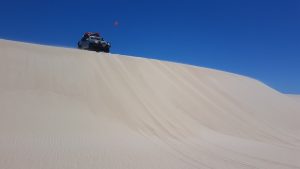 Aaron in his Patrol at the top of a dune.