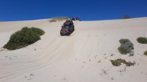 Adi takes his Jimny over the dune.