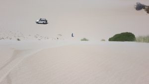Matt stands at the bottom of a large dune.