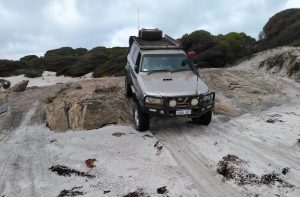 Scott takes his Patrol over the rock ledge onto Starvation Harbour Beach.